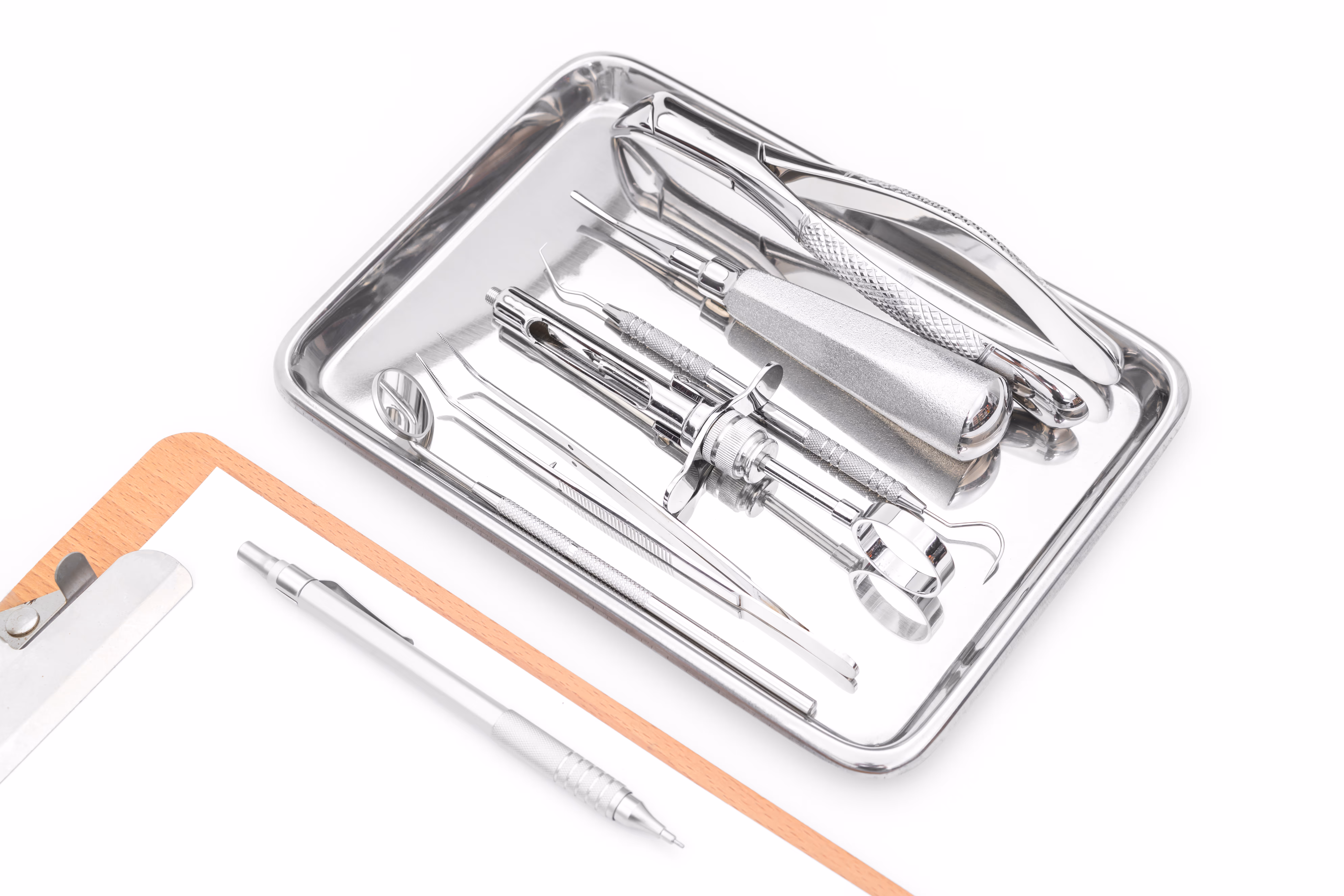 Instruments dentaires et un schéma dentaire disposés sur un fond blanc