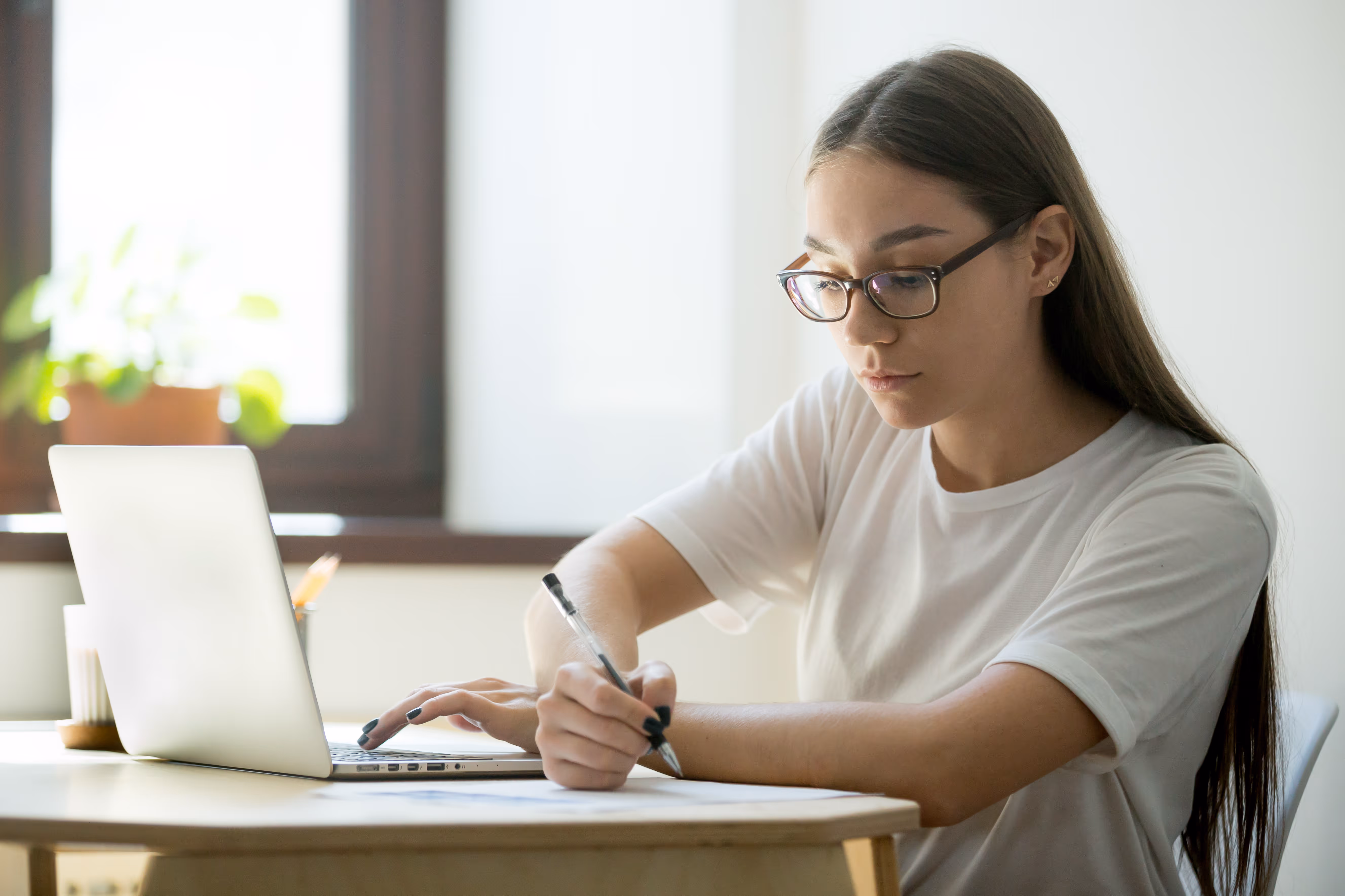Un étudiant se préparant à un examen avec un ordinateur portable et des notes